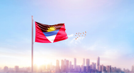 Obraz premium Antigua and Barbuda national flag waving with skyline and buildings. A beautiful view of flag with skyline.