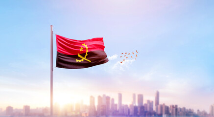Angola national flag waving with skyline and buildings. A beautiful view of flag with skyline. © Muhammad Arif