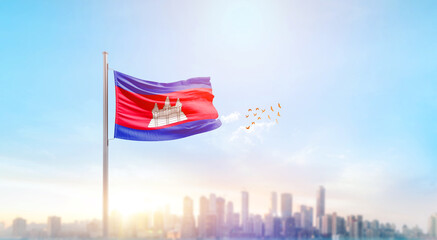 Obraz premium Cambodia national flag waving with skyline and buildings. A beautiful view of flag with skyline.