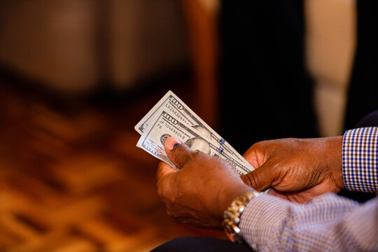 Money currency hands holding cash wedding event dowry payment Kenya Shillings Dollar