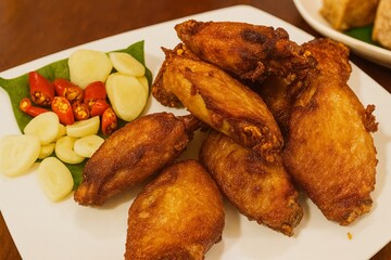 Crispy Thai Fried Chicken Wings with Fresh Garlic and Red Chili on Betel Leaf – Classic Thai Street Food