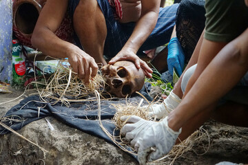 view of an archaeologists clean skulls from the ground