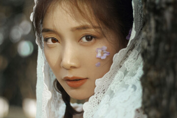 Portrait of a woman with delicate features and floral accents.