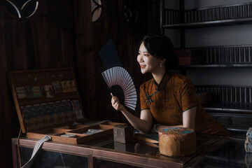 Woman with fan in vintage setting.