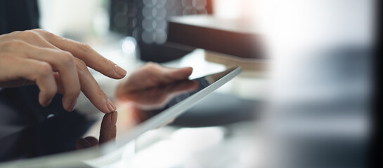 Close up. Woman using digital tablet for internet networking at office. Business finance and technology background