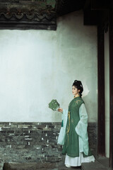 Female in traditional dress holding a fan Chinese word means fan.