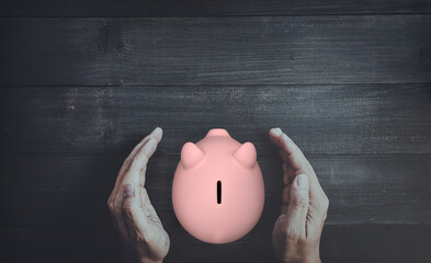 Senior Hands Protecting Pink Piggy Bank Symbolizing Financial Security and Retirement Savings
