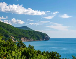 Lush green hills descend to a tranquil blue sea under a bright sky
