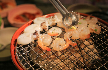 Squid, shrimp and vegetables grilling on grille, Fresh barbeque seafood in restaurant.
