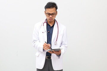 male doctor wearing doctor's coat, stethoscope hanging on neck, writing clinical notes, documents,...