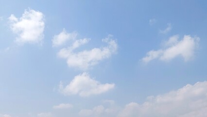 Bright sky with white fluffy clouds in summer. Blue sky with clouds. Soft white clouds float in the clear blue sky. Clear blue sky, bright spring, wallpaper landscape.