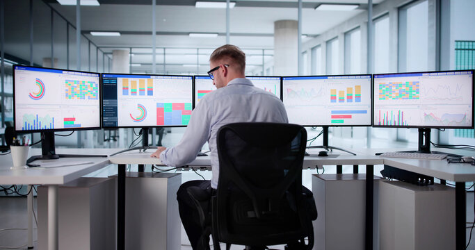 Young Caucasian Male Stock Analyst Using Computer