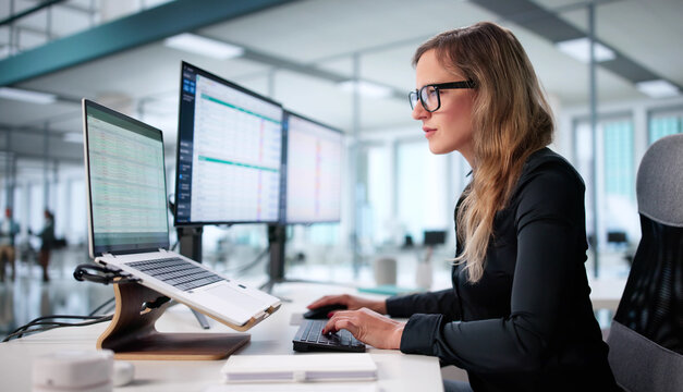 Woman In Office Analyzing Medical Billing Codes On Spreadsheet Reports