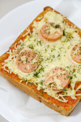 Homemade pizza made from white bread with sausage and cheese toppings