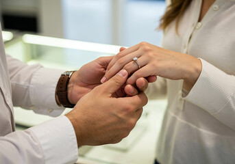 Man Gently Placing Diamond Engagement Ring on Woman's Finger During Proposal