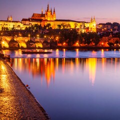 Fototapeta premium Night view of a riverside castle, illuminated, reflected in calm water