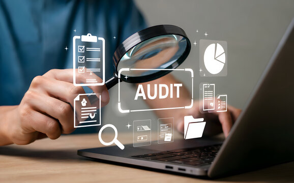 Financial Audit concept with magnifier analyzing data on modern laptop screen