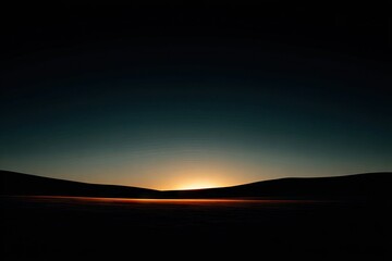 Dark landscape at sunrise. Silhouetted hills meet a vibrant sunrise
