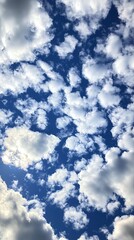 Obraz premium Bright blue sky with fluffy clouds and sunlight in a beautiful cloudscape