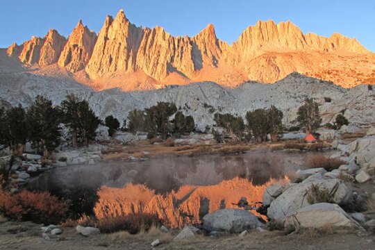 Mountain peaks reflected in calm alpine lake at sunrise