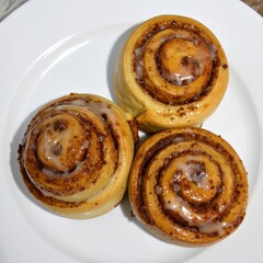 Fototapeta premium Three cinnamon rolls on a plate (1)