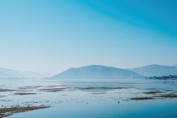 Tranquil lake scene with hazy mountains
