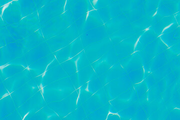 Blue water with ripples on the surface. Defocused, blurred, transparent, blue, clean, calm water surface texture. 