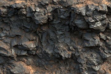 Close-up view of dark, rough rock face with sandy crevices