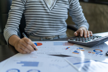A woman is writing on a piece of paper with a pen