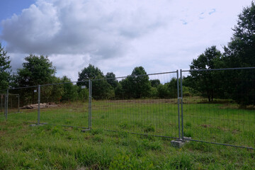 Empty enclosed with temporary fence the ground building.