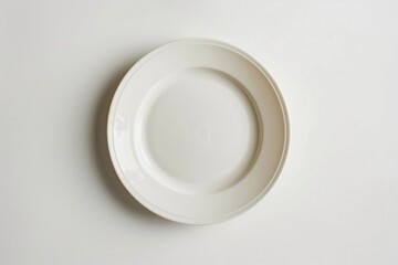 Simple empty plate displayed on a smooth surface emphasizing its round shape and minimalistic design