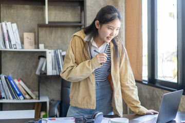 A woman is sitting at a desk with a laptop open