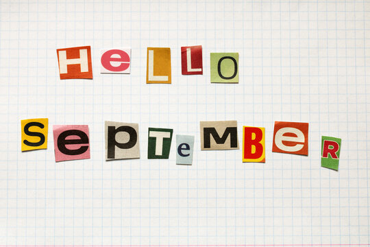 Hello september written with colorful newspaper cutout letters on graph paper