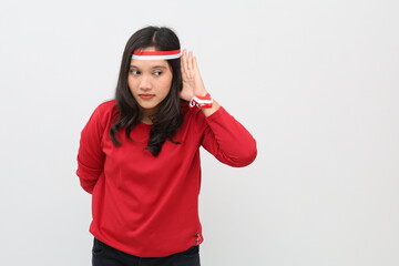 Indonesian women celebrating the independence of the Republic of Indonesia, putting their hands near their ears, curious facial expressions, listening to something, empty space on the side.