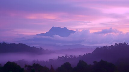 Obraz premium Purple hues paint a misty mountain landscape.