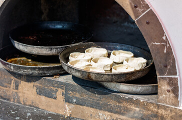 A pizza oven with a tray of dough balls on top