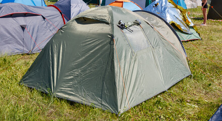 A tent is sitting in a field with other tents
