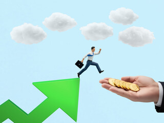 A miniature businessman jumps from a rising green arrow towards a hand holding a stack of golden coins.