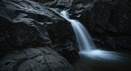 Serene Waterfall Cascading Over Dark Rocks: Nature Photography