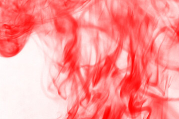 Vibrant abstract red smoke swirls against a deep black background evoking intense energy and passionate movement