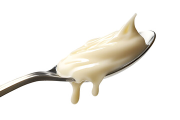 A close-up shot of a spoon with flowing of condensed milk. A trickle of milky goodness is gracefully dripping from the spoon