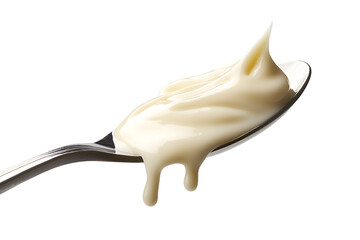 A close-up shot of a spoon with flowing of condensed milk. A trickle of milky goodness is gracefully dripping from the spoon