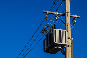 Electric power transformer on a pole with blue sky background in Brazil