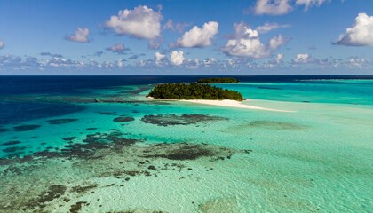 Obraz premium Aerial view of turquoise water surrounding small tropical islands, coral reefs visible beneath the surface