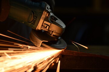 Dynamic close-up of angle grinder sparks in low light for industrial use