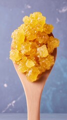 Ultra macro view of crystallized golden honey on wooden spoon
