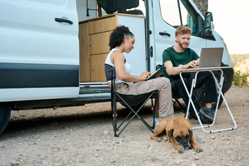 Couple working remotely from camper van with dog