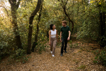 Fototapeta premium Hikers walking and talking in beautiful forest trail