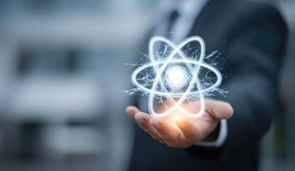 A businessman's hand holds a glowing atom symbol