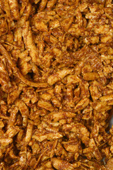 A pile of grated smoked tofu in a soy and mustard marinade creates a textured brown background